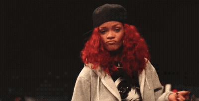 A Woman With Red Hair Is Wearing A Hat And A Hoodie And Giving The Middle Finger . GIF