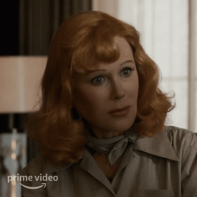 A Woman With Red Hair Is Wearing A White Shirt And A Scarf And The Word Prime Video Is On The Bottom GIF