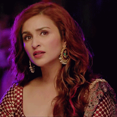 A Woman With Red Hair Is Wearing Earrings GIF