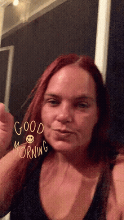A Woman With Red Hair Says Good Morning With A Smiley Face On Her Face GIF