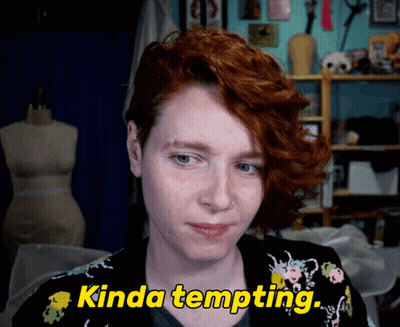 A Woman With Red Hair Says " Kinda Tempting " In Yellow Letters GIF