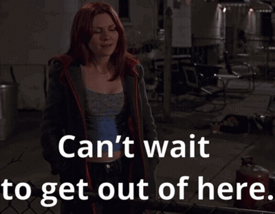A Woman With Red Hair Stands In Front Of A Fence With The Words Can 'T Wait To Get Out Of Here GIF