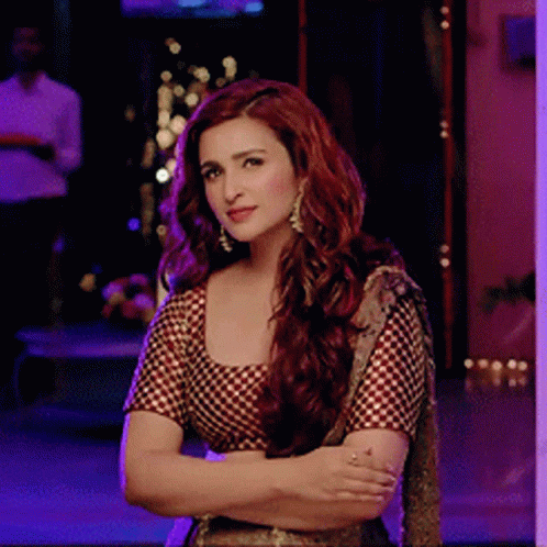 A Woman With Red Hair Stands With Her Arms Crossed GIF