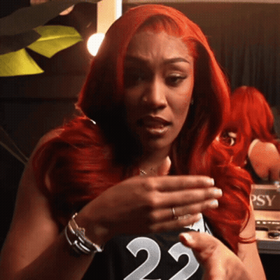 A Woman With Red Hair Wearing A Black Jersey With The Number 22 On It GIF