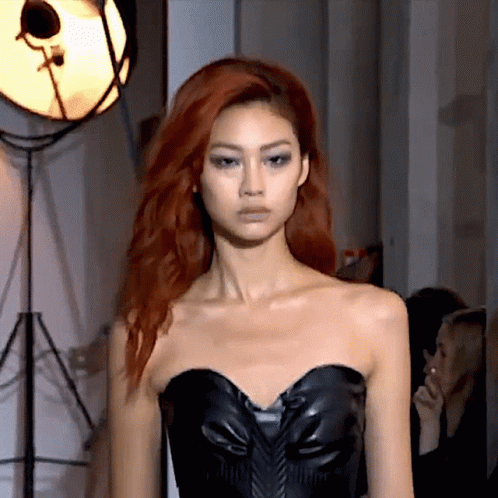 A Woman With Red Hair Wearing A Black Strapless Top GIF