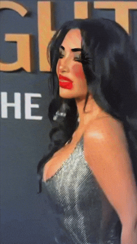 A Woman With Red Lips Is Standing In Front Of A Sign That Says ' He ' GIF
