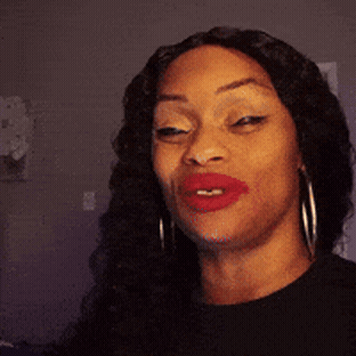 A Woman With Red Lipstick And Hoop Earrings Is Making A Funny Face . GIF