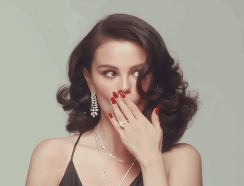 A Woman With Red Lipstick And Red Nails Is Wearing A Black Dress GIF