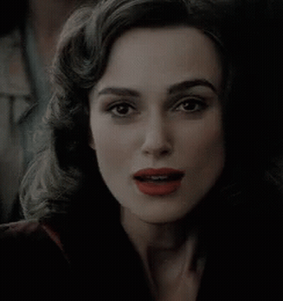 A Woman With Red Lipstick Is Smiling And Looking At The Camera GIF