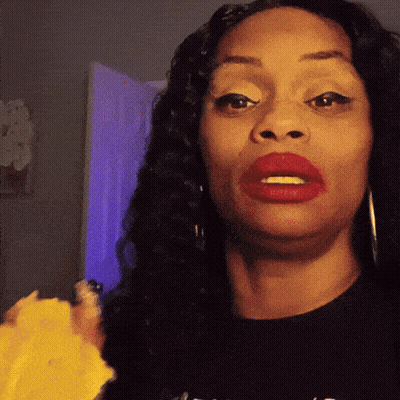 A Woman With Red Lipstick Is Wearing A Black Shirt That Says ' A ' On The Front GIF