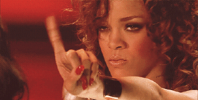 A Woman With Red Nail Polish Is Looking At Herself In The Mirror GIF