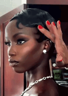 A Woman With Red Nails And A Necklace Is Getting Her Hair Done . GIF