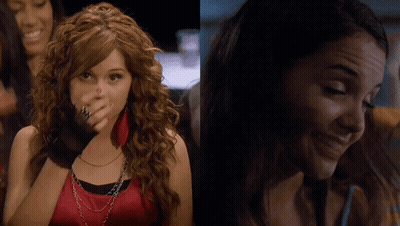 A Woman With Red Nails Is Covering Her Face With Her Hand And Another Woman Is Smiling GIF