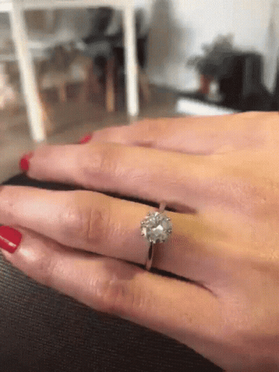 A Woman With Red Nails Is Wearing A Diamond Ring On Her Left Hand GIF