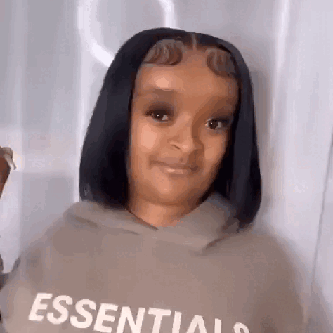 A Woman With Short Black Hair Is Wearing A Hoodie And Smiling . GIF