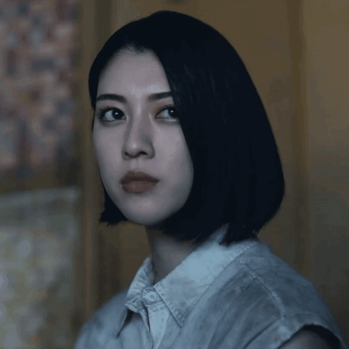 A Woman With Short Black Hair Looks At The Camera GIF