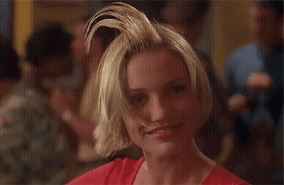 A Woman With Short Blonde Hair Is Making A Funny Face . GIF