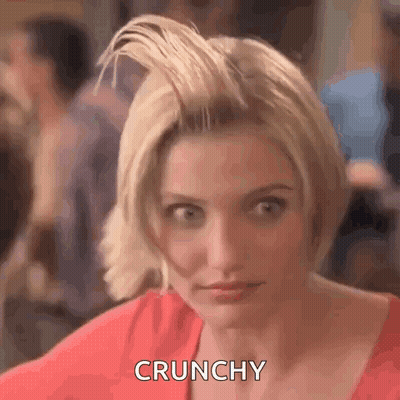 A Woman With Short Blonde Hair Is Making A Funny Face And Saying Crunchy . GIF