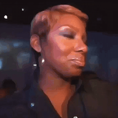 A Woman With Short Hair Is Making A Funny Face While Wearing A Black Shirt And Earrings . GIF