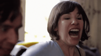 A Woman With Short Hair Is Screaming With Her Mouth Open . GIF