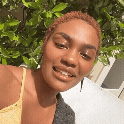 A Woman With Short Red Hair Is Smiling For The Camera GIF