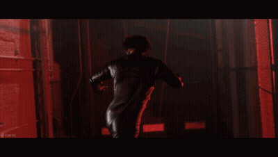 A Woman With Spikes On Her Body Is In A Dark Room With Red Lights GIF