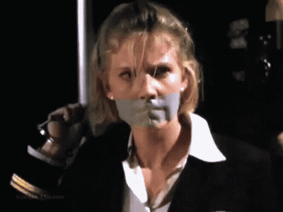 A Woman With Tape On Her Mouth Is Holding A Knife . GIF