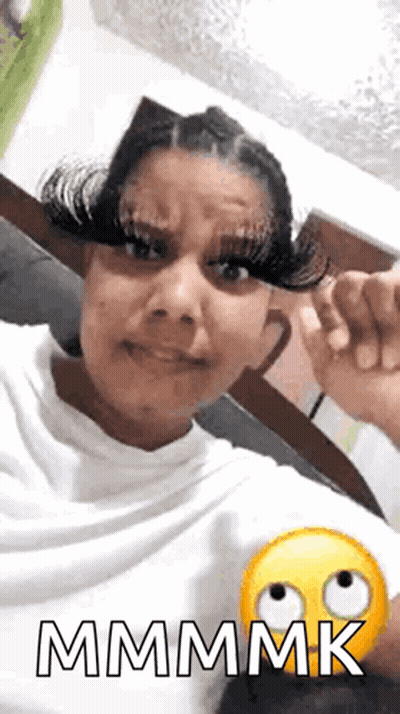 A Woman With Very Long Eyelashes Is Making A Funny Face And Giving A Thumbs Up . GIF