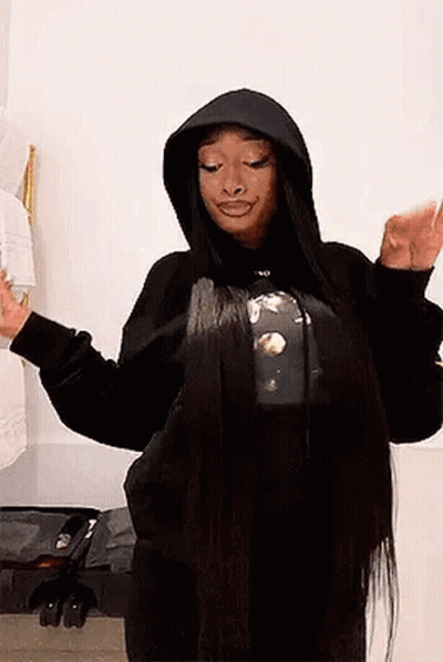 A Woman With Very Long Hair Is Wearing A Black Hoodie And A T-Shirt . GIF