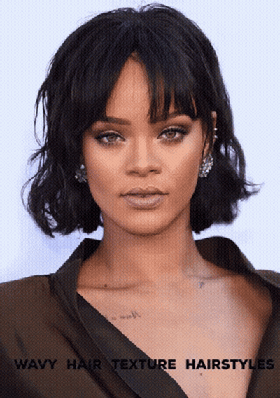 A Woman With Wavy Hair And A Tattoo On Her Chest GIF