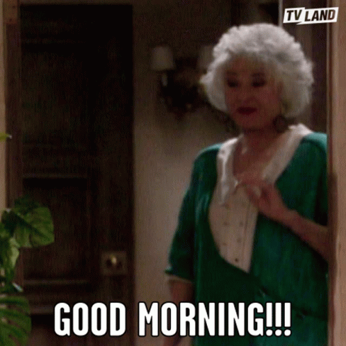 A Woman With White Hair And A Green Shirt Says Good Morning GIF