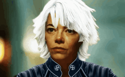 a woman with white hair is wearing a blue jacket with a symbol on the collar