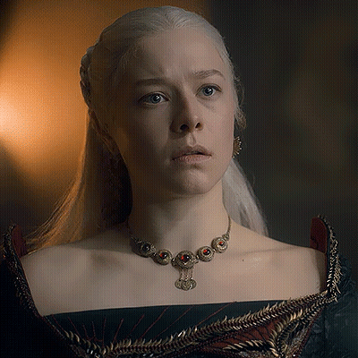 A Woman With White Hair Is Wearing A Necklace And Earrings . GIF