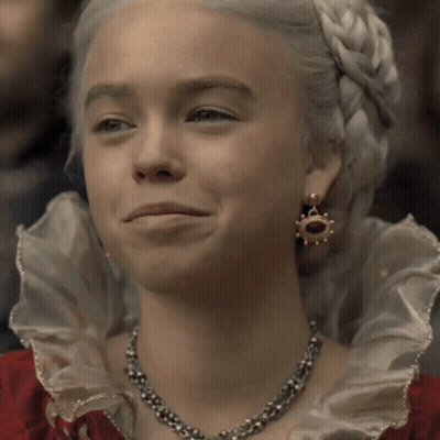 A Woman With White Hair Wearing A Necklace And Earrings Smiles GIF