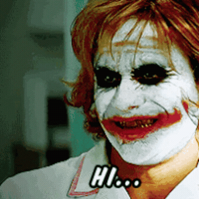 A Woman With White Paint On Her Face And The Word Hi On Her Chest GIF