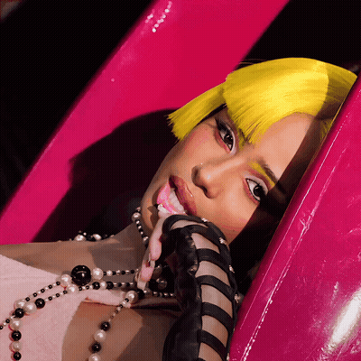 A Woman With Yellow Hair And A Pearl Necklace GIF