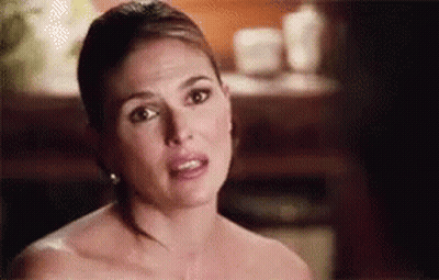 A Woman Without A Shirt Is Making A Funny Face While Looking At The Camera . GIF