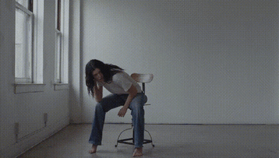 A Woman Without A Shirt Is Taking Off Her Shirt GIF