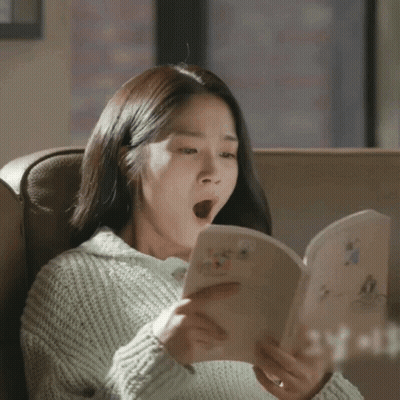 A Woman Yawning While Reading A Book That Says Yeah GIF