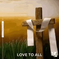 A Wooden Cross With A White Ribbon Around It Is Sitting In The Grass . GIF