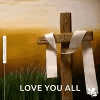 A Wooden Cross With A White Ribbon Tied Around It . GIF