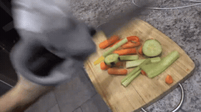 A Wooden Cutting Board With Carrots Celery And Peppers On It GIF