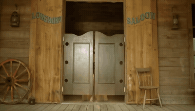 A Wooden Saloon With A Wagon Wheel And A Chair GIF