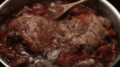 A Wooden Spoon Is Being Used To Stir A Pot Of Food . GIF