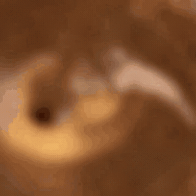 A Wooden Spoon Is Stirring A Brown Liquid In A Bowl GIF