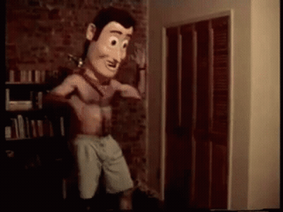 A Woody Doll Is Standing In A Room With His Shirt Off . GIF