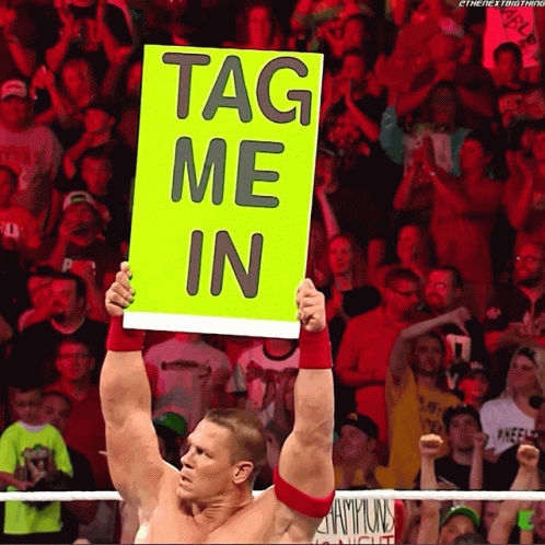 A Wrestler Holds Up A Sign That Reads Tag Me In GIF