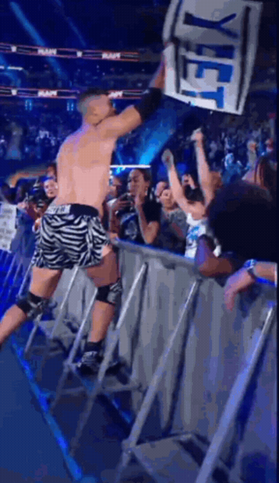 A Wrestler Holds Up A Sign That Says Yet In Front Of A Crowd GIF