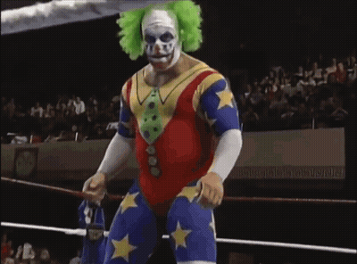 A Wrestler In A Clown Costume Is Standing In A Ring GIF