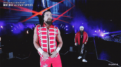 A Wrestler In A Red And White Outfit Is Walking Down A Ramp GIF